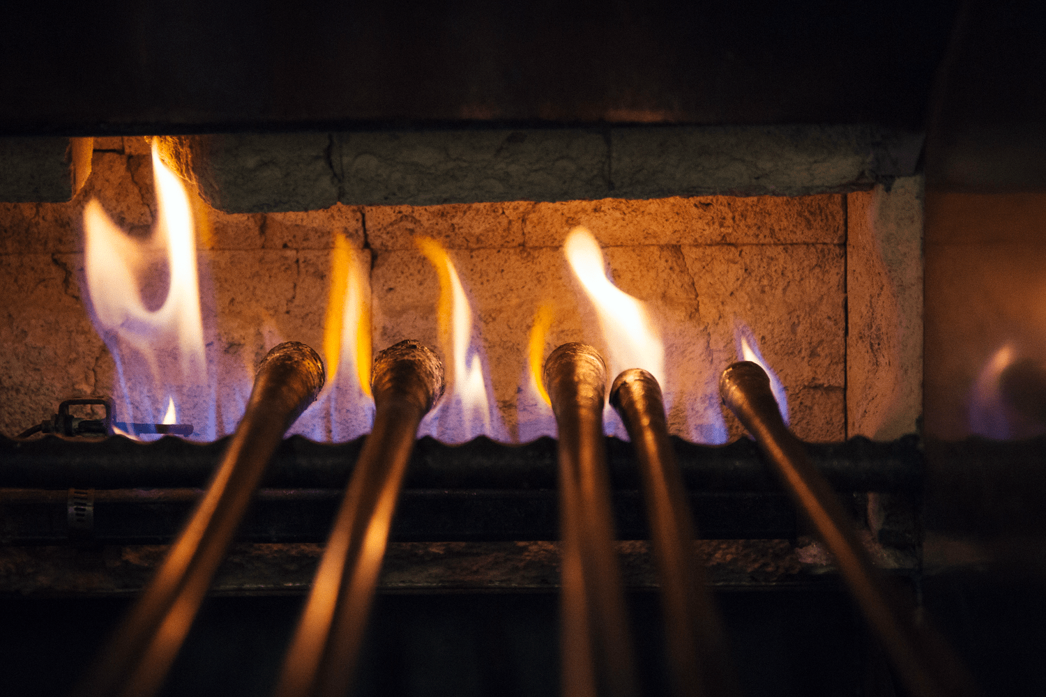 Photograph Of Metal Rods Being Heated Over An Open Flame.